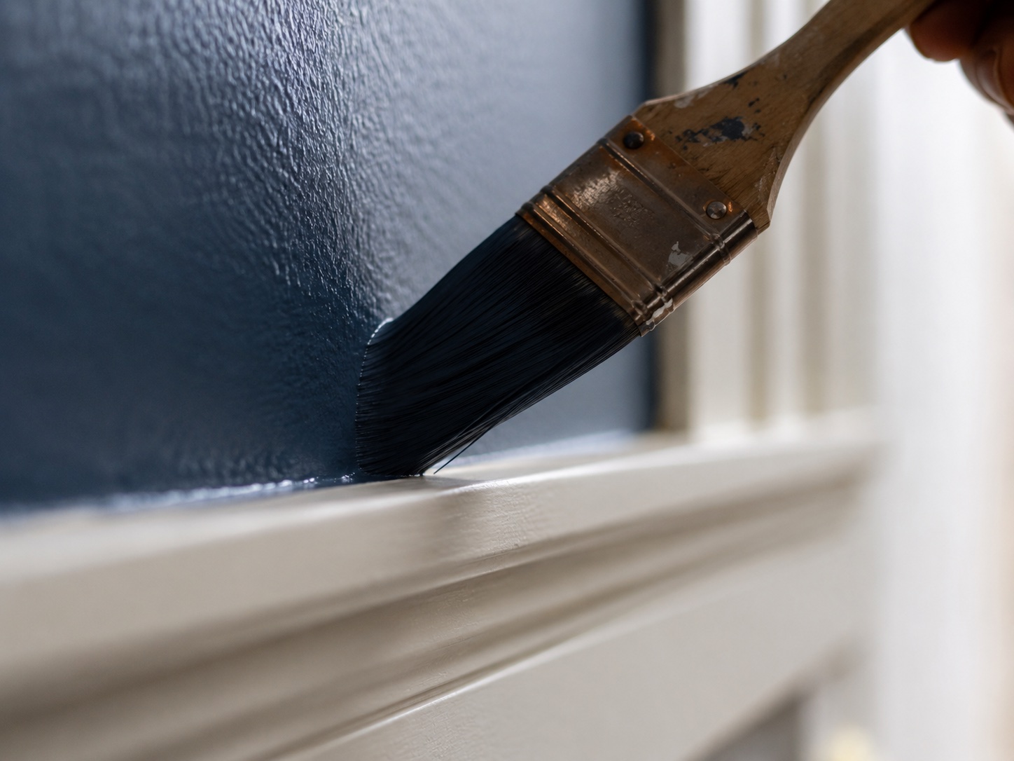 Painter cutting a clean line along trim
